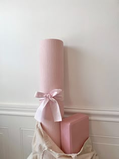 a stack of pink blocks sitting on top of a pile of white cloth next to a wall