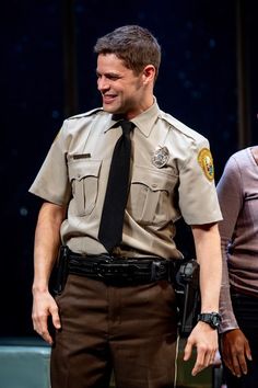 a man in a police uniform standing next to a woman