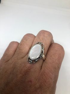 Lovely polished sterling silver has the look of Deco with a huge white Mother Of Pearl set in very detailed vintage filigree Size 7.75 We can size these with an additional $10-$20 fee for the jeweler All rings are shipped in a nice gift box. Check out our over a THOUSAND great reviews Engraving is $4 per letter and is not always perfect depending on the piece. It can take a few days if the jeweler is busy. This is payable to Paypal Judithsltd@gmail.com Classic White Filigree Ring With Intricate Design, White Heirloom Filigree Ring With Intricate Design, Heirloom White Filigree Ring With Intricate Design, White Filigree Fine Jewelry, White Filigree Ring With Intricate Design For Formal Events, Classic White Oval Cabochon Ring, White Fine Jewelry With Filigree Details, White Fine Jewelry With Filigree, Fine White Filigree Jewelry