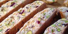 several pieces of bread with nuts and cranberry toppings sitting on a table