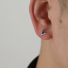 a man wearing a pair of silver ear studs with triangle design on each side