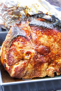 a piece of meat sitting on top of a pan covered in foil