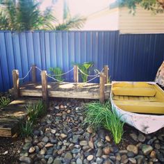 a small boat sitting on top of a pile of rocks next to a wooden dock