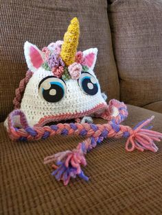 a crocheted unicorn hat sitting on top of a couch