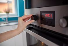 a person adjusting the temperature on an oven