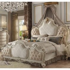 an ornate bedroom with white furniture and chandelier