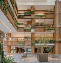 the inside of an office building with plants growing on the walls and balconies