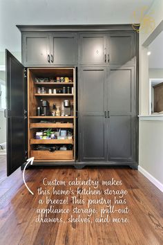 A floor-to-ceiling custom pantry with black cabinets and natural wood interior. The large pantry has French hideaway doors, which are seen in action as half of the pantry is open in the image. Inside the cabinet are two coffee machines, pull-out drawers, and plenty of shelving. The image has text that reads, "Custom cabinetry makes this home's kitchen storage a breeze! This pantry has appliance storage, pull-out drawers, shelves, and more." with an arrow pointing to the interior of the pantry. Pantry Wall Ideas Built Ins, Kitchen With Pantry Cabinet, Standalone Pantry, Built In Pantry Cabinet Wall, Barndo House, Lakehouse Kitchen, Whole House Remodel, Kitchen 2024, Built In Pantry