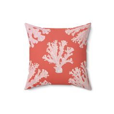 an orange and white coral pillow on a white background