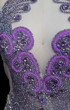 the back of a dress with purple beads and sequins on it's neck