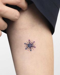 a woman's thigh with a tattoo on it that has an image of a snowflake