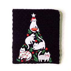 an embroidered christmas tree with cats on it