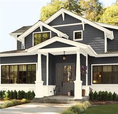 a gray house with white trim and pillars