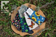 five handkerchiefs laid out on a wooden plate in the grass