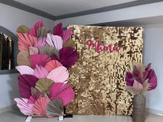 there is a vase with flowers in front of a gold sequined wall decoration