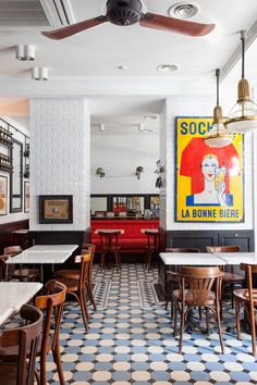 the interior of a restaurant with blue and white checkered flooring, wooden tables and chairs