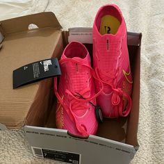 a pair of pink nike shoes are in a box on the floor next to a cardboard box