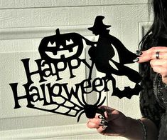 a woman holding a knife in front of a stencil that says happy halloween