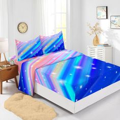 a bed room with a neatly made bed and a night sky print on the comforter