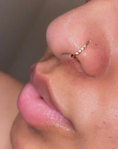 a woman's nose with a tiny gold nose ring on top of her nose