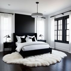 a black and white bedroom with sheepskin rugs on the floor, windows, and bed