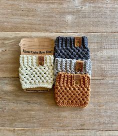 four crocheted purses sitting on top of a wooden table