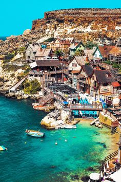 an aerial view of a village on the water's edge with boats in it