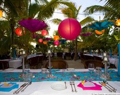 an outdoor dining area with tables, chairs and paper lanterns hanging from the ceiling above