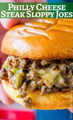 a close up of a person holding a sandwich with meat and vegetables on it in their hand