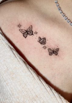 a woman's shoulder with three butterflies on the left side of her body and one is