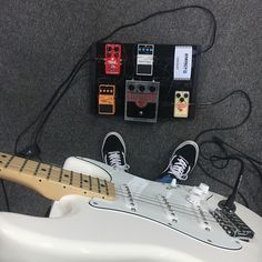 an electric guitar sitting on the ground next to some pedals