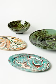 three bowls with different designs on them sitting next to each other in front of a white background