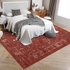 a bed sitting on top of a wooden floor next to a white dresser and chair