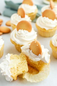 several cupcakes with white frosting and one has an egg on top that is cut in half