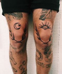 a man's legs with tattoos on them