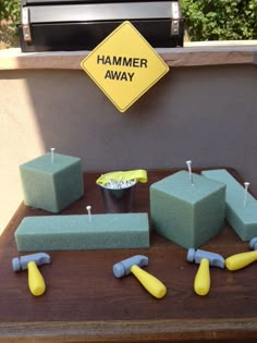 an outdoor grill with several pieces of green and yellow sanding blocks sitting on top of it