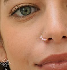 a close up of a woman's nose with an upside down nose ring on it