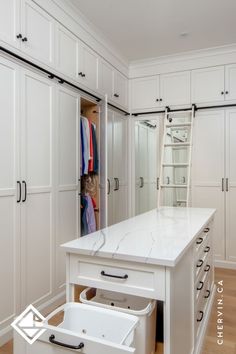 A white walk-in closet with a rolling ladder and Closet Pull Out, Closet With Middle Island, Master Closet Center Island, Closet With Ladder Small Spaces, Closet With Lots Of Drawers, Walk In Closet Design With Island, Walk In Closet Seating Ideas, Condo Walk In Closet Ideas, Small Closet With Island