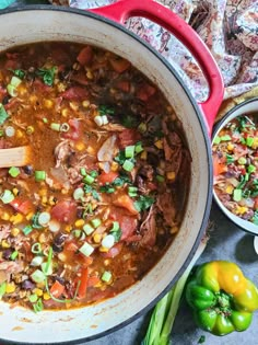 a large pot filled with soup next to some vegetables and other foods on the table