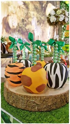 there are zebra, tiger and giraffe decorated eggs on the tree stumps