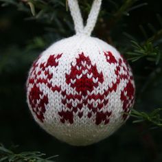 a red and white ornament hanging from a tree