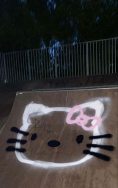 a cat drawn on the ground in front of a fence