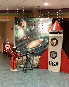 an astronaut standing in front of a nasa rocket on display at the children's museum