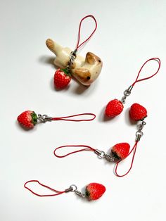 the necklaces are made to look like strawberries and a teddy bear with a banana on it