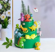 there is a cake decorated with dinosaurs and plants on the top, as well as other decorations