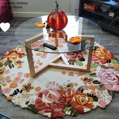 a glass table with flowers on it and a phone sitting on top of the table