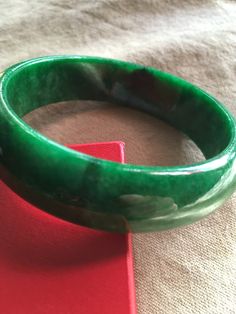 62.53 mm Swirly Green Moss Jadeite Bangle Bracelet #421 Size: 62.53 mm x 8mm x 18mm Weight: 72.61g = 363.05 Ct This is a weighty, solid piece of jade with some natural stone wen lines! Great starter bangle! Priced accordingly. Gem certificate included with purchase. Green Bangle Bracelet For Formal Occasions, Green Bangle Bracelets For Formal Occasions, Elegant Oval Green Bangle, Formal Green Bangle Bracelets, Elegant Green Oval Bangle, Green Classic Bangle For Formal Occasions, Elegant Green Round Bangle, Green Jade Bracelets For Formal Occasions, Classic Green Bangle Jewelry