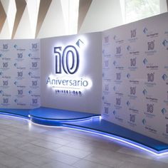 the 10th anniversary sign is lit up in front of an event backdrop with blue lighting