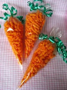 three carrots wrapped in cellophane with green bows