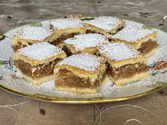 a plate that has some desserts on it with powdered sugar around the edges